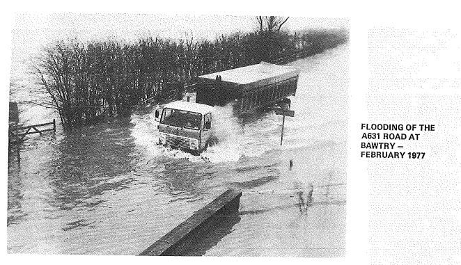 Historic image showing flooding of the A631 road at Bawtry in 1977, with a lorry driving through the water.