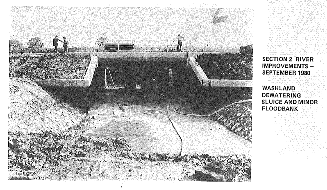 Image of river improvements from 1980, showing excavation work under a bridge. 