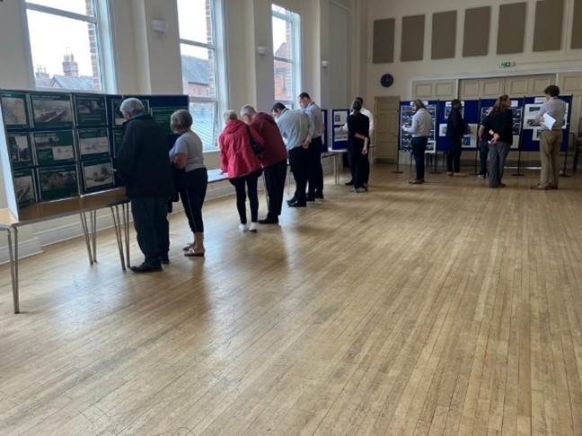 Picture showing members of the public viewing display stands about the design of the scheme.