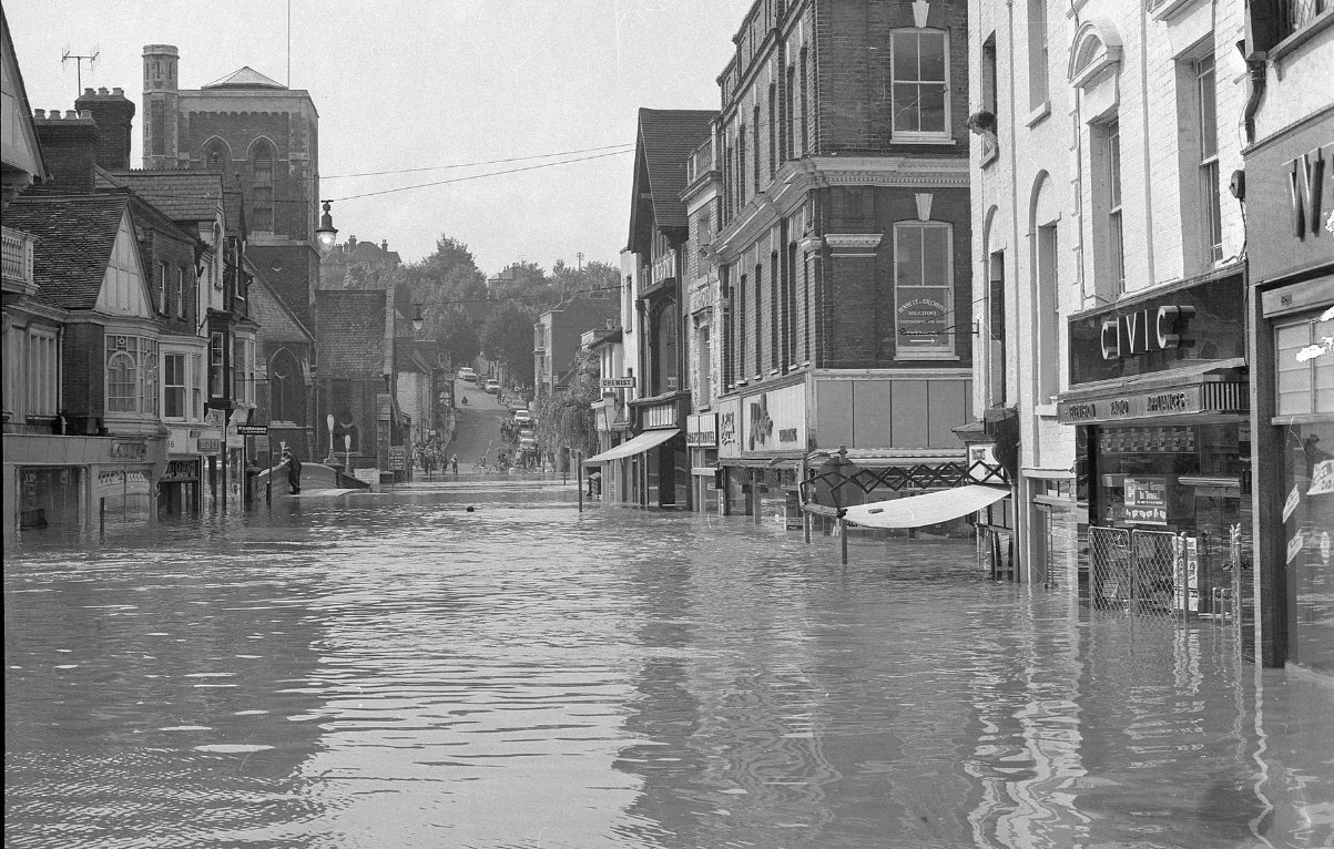Guildford in 1968 showing flooding of shops, water level is up to door handles and one awning is only just above the flood water